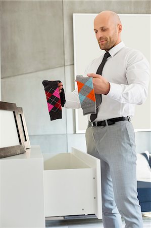 Mid adult businessman selecting socks at home Photographie de stock - Premium Libres de Droits, Code: 693-07912371
