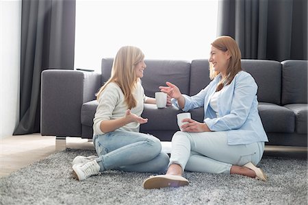 Happy mother and daughter talking while having coffee in living room Photographie de stock - Premium Libres de Droits, Code: 693-07912405