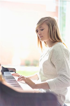 female pianist - Teenage girl playing piano at home Stock Photo - Premium Royalty-Free, Code: 693-07912411