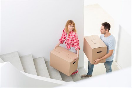 simsearch:693-07912629,k - Happy couple carrying moving boxes up stairs in new house Stock Photo - Premium Royalty-Free, Code: 693-07912571