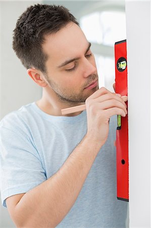 simsearch:693-07912629,k - Mid-adult man marking on wall with level Stock Photo - Premium Royalty-Free, Code: 693-07912588