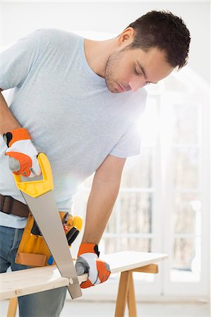Man sawing wood in new house Stock Photo - Premium Royalty-Free, Code: 693-07912597