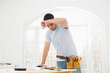 simsearch:693-07912629,k - Mid-adult carpenter wiping his brow in new house Stock Photo - Premium Royalty-Free, Code: 693-07912603