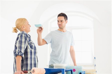 simsearch:693-07912629,k - Playful man putting paint on woman's nose in new house Stock Photo - Premium Royalty-Free, Code: 693-07912638
