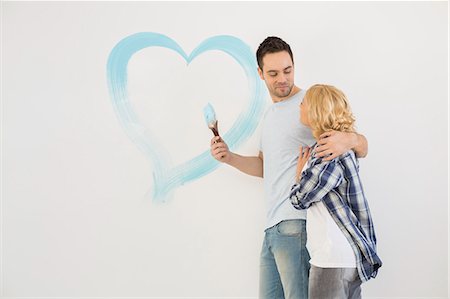 simsearch:693-07912629,k - Loving mid-adult couple with painted heart on wall Stock Photo - Premium Royalty-Free, Code: 693-07912646