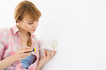 electrical outlet - Woman working on electrical outlet Stock Photo - Premium Royalty-Free, Code: 693-07912656