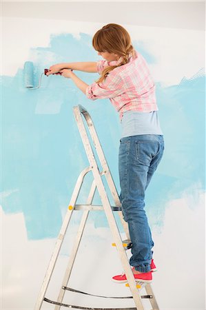 european painting - Woman on ladder painting wall with paint roller Stock Photo - Premium Royalty-Free, Code: 693-07912671