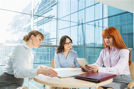 focused professional - Businesswomen using digital tablet in office Stock Photo - Premium Royalty-Free, Code: 693-07912733