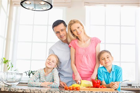 simsearch:6108-06907066,k - Portrait of happy family preparing food in kitchen Stock Photo - Premium Royalty-Free, Code: 693-07912789