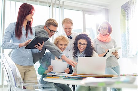 simsearch:693-07542313,k - Smiling creative businesspeople working on laptop at desk in office Stock Photo - Premium Royalty-Free, Code: 693-07912967