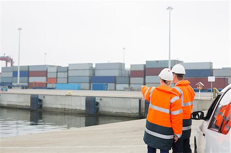 Workers in protective clothing examining cargo in shipping yard Stock Photo - Premium Royalty-Free, Code: 693-07913064