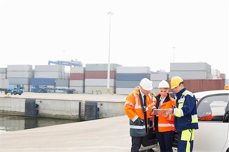 Workers using tablet PC beside car in shipping yard Stock Photo - Premium Royalty-Free, Code: 693-07913088