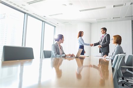 simsearch:400-05709555,k - Businessman and businesswoman shaking hands in conference room Stock Photo - Premium Royalty-Free, Code: 693-07913205