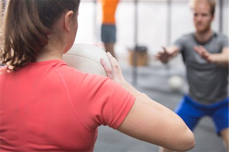 simsearch:693-08126938,k - Rear view of woman throwing medicine ball towards man in crossfit gym Stock Photo - Premium Royalty-Free, Code: 693-08126929