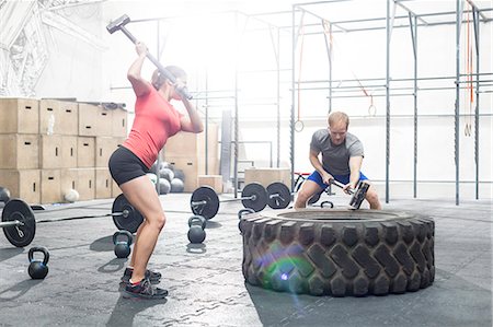 simsearch:693-08126938,k - Dedicated man and woman hitting tire with sledgehammer in crossfit gym Stock Photo - Premium Royalty-Free, Code: 693-08126935