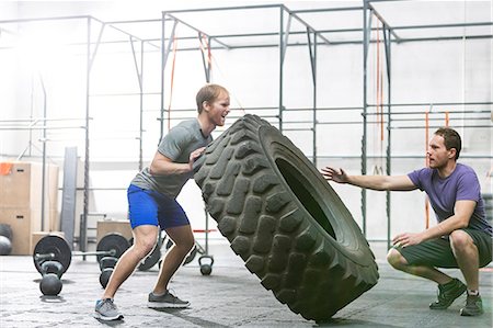 simsearch:693-08126938,k - Man assisting at dedicated friend in flipping tire at crossfit gym Stock Photo - Premium Royalty-Free, Code: 693-08126931