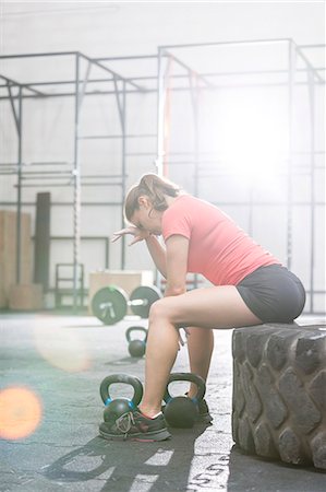 simsearch:693-08126938,k - Tired woman sitting on tire in crossfit gym Stock Photo - Premium Royalty-Free, Code: 693-08126950