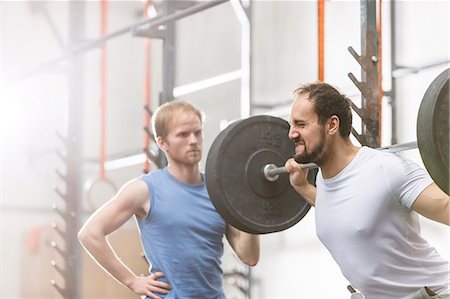 simsearch:693-08126938,k - Man assisting friend in lifting barbell at crossfit gym Stock Photo - Premium Royalty-Free, Code: 693-08126975