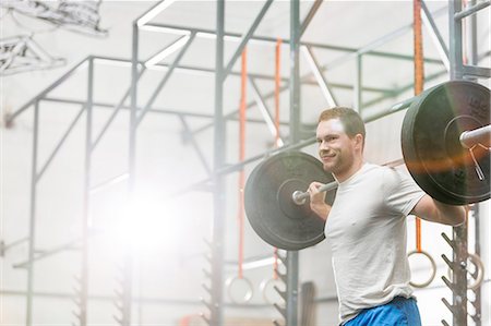 simsearch:693-08126938,k - Smiling man lifting barbell at crossfit gym Stock Photo - Premium Royalty-Free, Code: 693-08126976