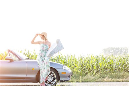 road map - Happy woman holding map while standing by convertible on sunny day Stock Photo - Premium Royalty-Free, Code: 693-08127044