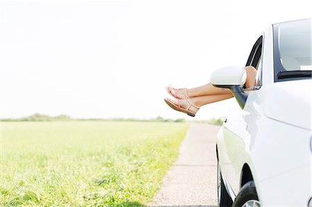 Low section of woman relaxing in car on country road Stock Photo - Premium Royalty-Free, Code: 693-08127055