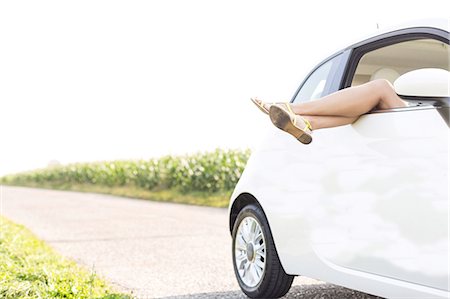 Low section of woman relaxing in car on country road Stock Photo - Premium Royalty-Free, Code: 693-08127113