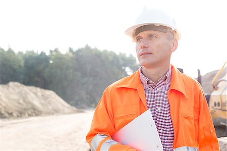 Thoughtful engineer holding clipboard against clear sky Stock Photo - Premium Royalty-Free, Code: 693-08127749