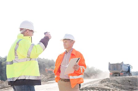 Supervisors discussing at construction site against clear sky Stock Photo - Premium Royalty-Free, Code: 693-08127766