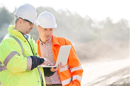 Supervisors using laptop at construction site Stock Photo - Premium Royalty-Free, Code: 693-08127772