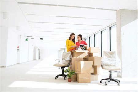 simsearch:614-08030536,k - Businesswomen unpacking cardboard boxes in new office Stock Photo - Premium Royalty-Free, Code: 693-08769254
