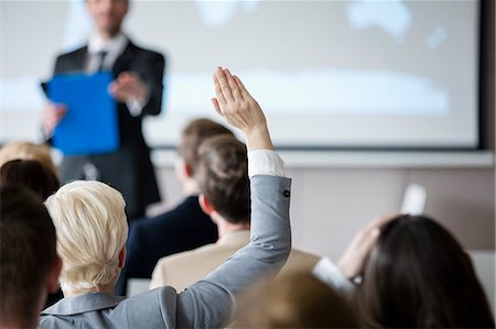 speech - Rear view of businesswoman raising hand during seminar Stock Photo - Premium Royalty-Free, Code: 693-08769389