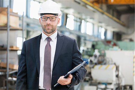 Portrait of confident mid adult male supervisor holding clipboard in metal industry Stock Photo - Premium Royalty-Free, Code: 693-08769478