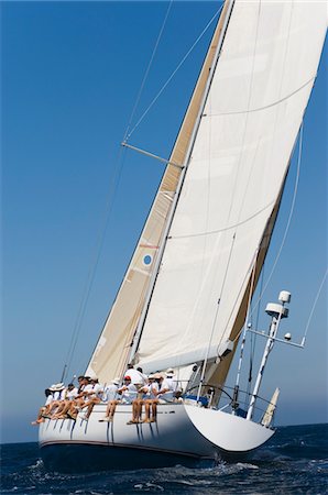 simsearch:693-03314237,k - Crew sitting on Side of sailboat, side view Stock Photo - Premium Royalty-Free, Code: 693-03299365