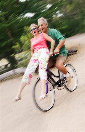 Woman riding on handlebars of mans bicycle Stock Photo - Premium Royalty-Free, Code: 693-03299457