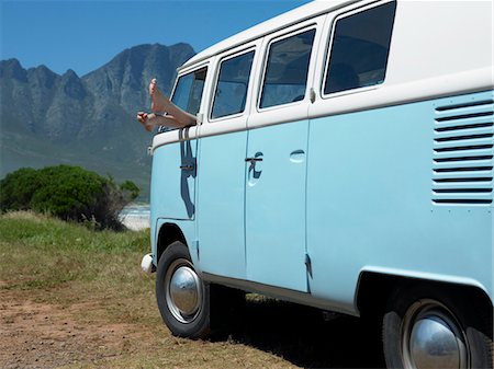 sticking out - Person in parked camper van, feet sticking out of window Foto de stock - Sin royalties Premium, Código: 693-03304519