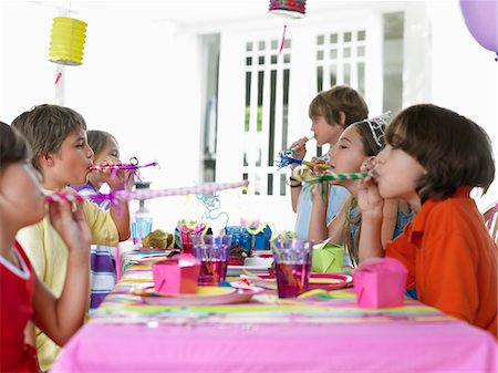 simsearch:693-03305634,k - Six children (7-12) at table, blowing party puffers, side view Stock Photo - Premium Royalty-Free, Code: 693-03305580