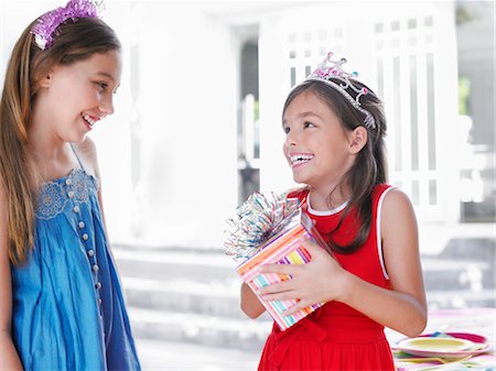 simsearch:693-03305634,k - Two girls (7-9, 10-12) at birthday party, one holding present, smiling Stock Photo - Premium Royalty-Free, Code: 693-03305599