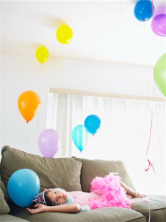 simsearch:693-03305634,k - Young girl (7-9) lying on sofa looking at balloons Stock Photo - Premium Royalty-Free, Code: 693-03305634