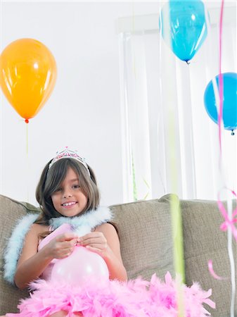 simsearch:693-03305634,k - Young girl (7-9) on sofa preparing birthday balloons Stock Photo - Premium Royalty-Free, Code: 693-03305636