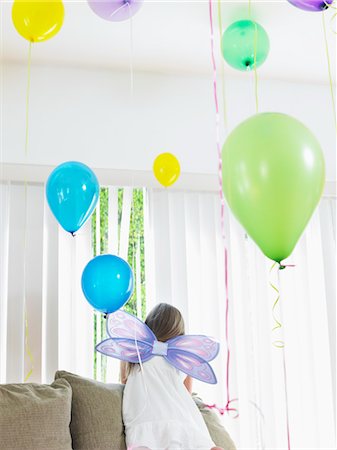 simsearch:693-03305634,k - Young girl (7-9) climbing on sofa, wearing fairy wings, back view Stock Photo - Premium Royalty-Free, Code: 693-03305637