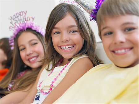 simsearch:693-03305634,k - Children (7-12) sitting in row at birthday party, selective focus Stock Photo - Premium Royalty-Free, Code: 693-03305652