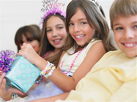 simsearch:693-03305634,k - Children (7-12) sitting in row at birthday party, one holding present Stock Photo - Premium Royalty-Free, Code: 693-03305653