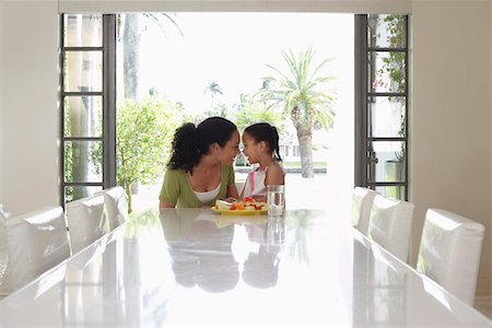 Mother and daughter (5-6 years) sitting at dining table Stock Photo - Premium Royalty-Free, Code: 693-03305702