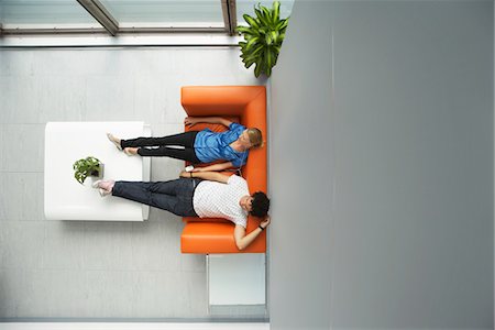 Two people reclining on couch in reception room, view from above Stock Photo - Premium Royalty-Free, Code: 693-03307877