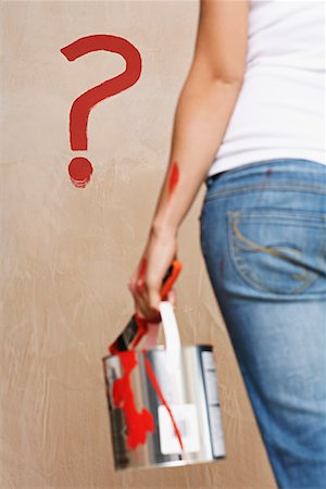 question mark symbol - Woman holding painting can facing wall with painted question mark, mid section, back view Stock Photo - Premium Royalty-Free, Code: 693-03308073