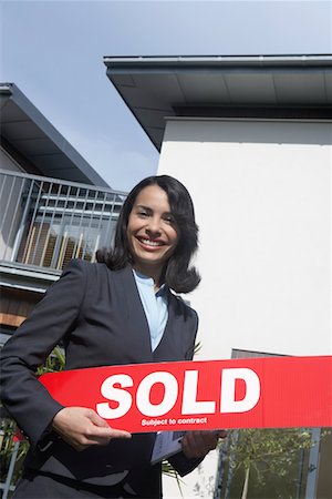 simsearch:693-03308239,k - Real estate agent holding sold sign outside house, portrait Stock Photo - Premium Royalty-Free, Code: 693-03308240
