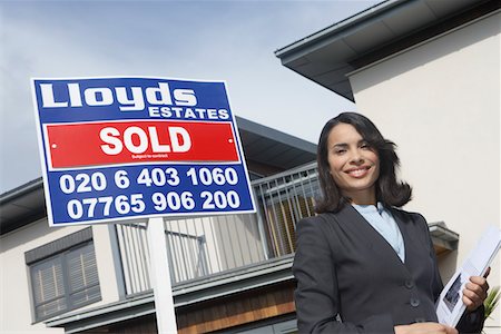 sold sign - Real estate agent beside sold sign outside house, portrait Stock Photo - Premium Royalty-Free, Code: 693-03308241