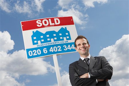 simsearch:693-03308239,k - Real estate agent in front of sold sign, against cloudy sky Stock Photo - Premium Royalty-Free, Code: 693-03308293
