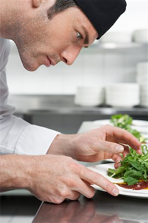 Male chef preparing salad in kitchen, close-up Stock Photo - Premium Royalty-Free, Code: 693-03308922