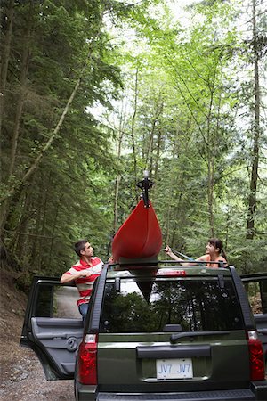 Man tying kayak on car roof, in forest Stock Photo - Premium Royalty-Free, Code: 693-03309078